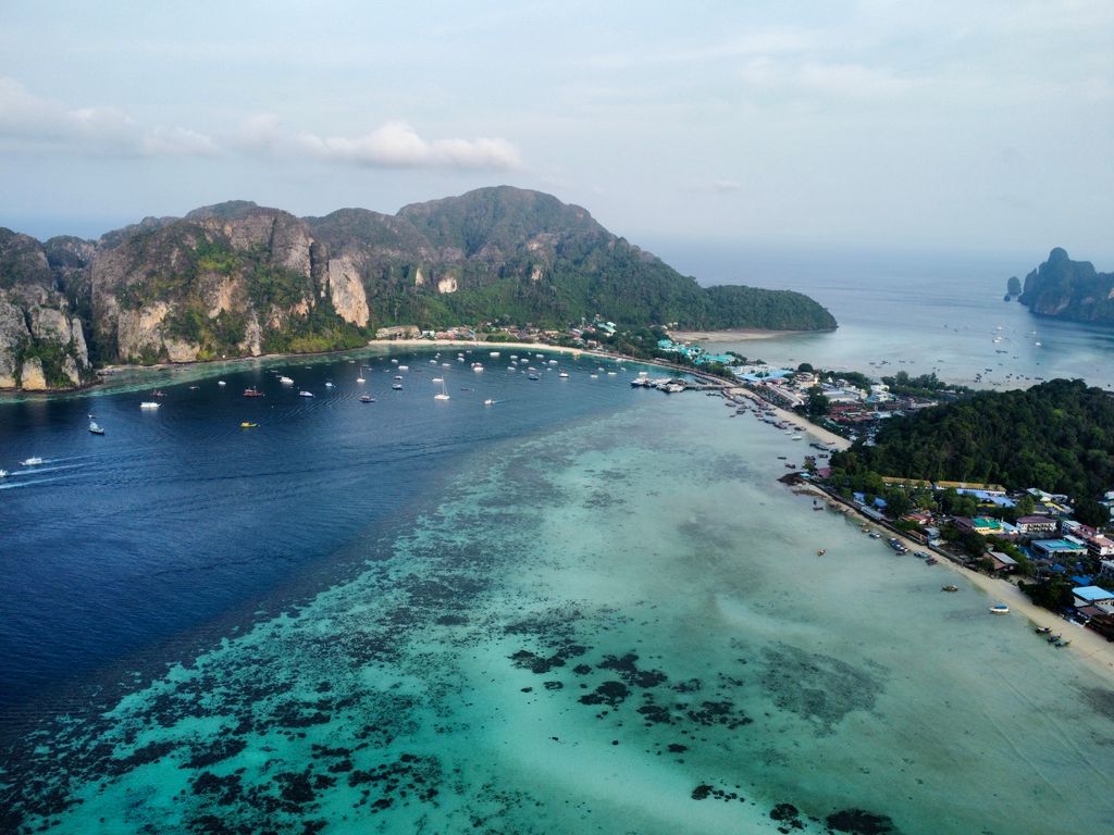 A breathtaking aerial shot of the picturesque Phi Phi Islands' coastline, showcasing crystal-clear turquoise waters.